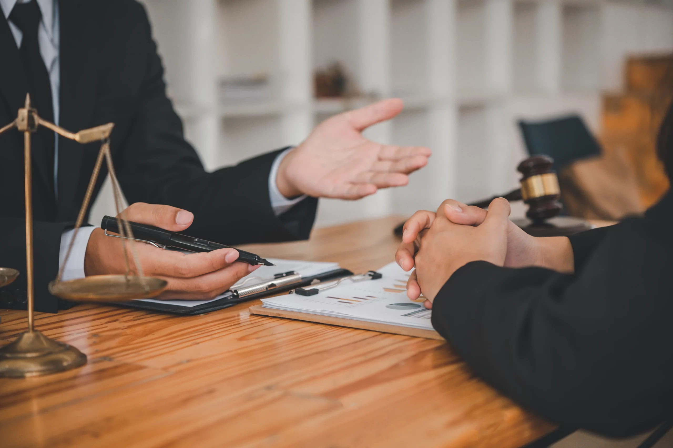 Business professionals consulting with a Missouri civil litigation lawyer over legal documents, with scales of justice and a gavel representing dispute resolution and courtroom representation.