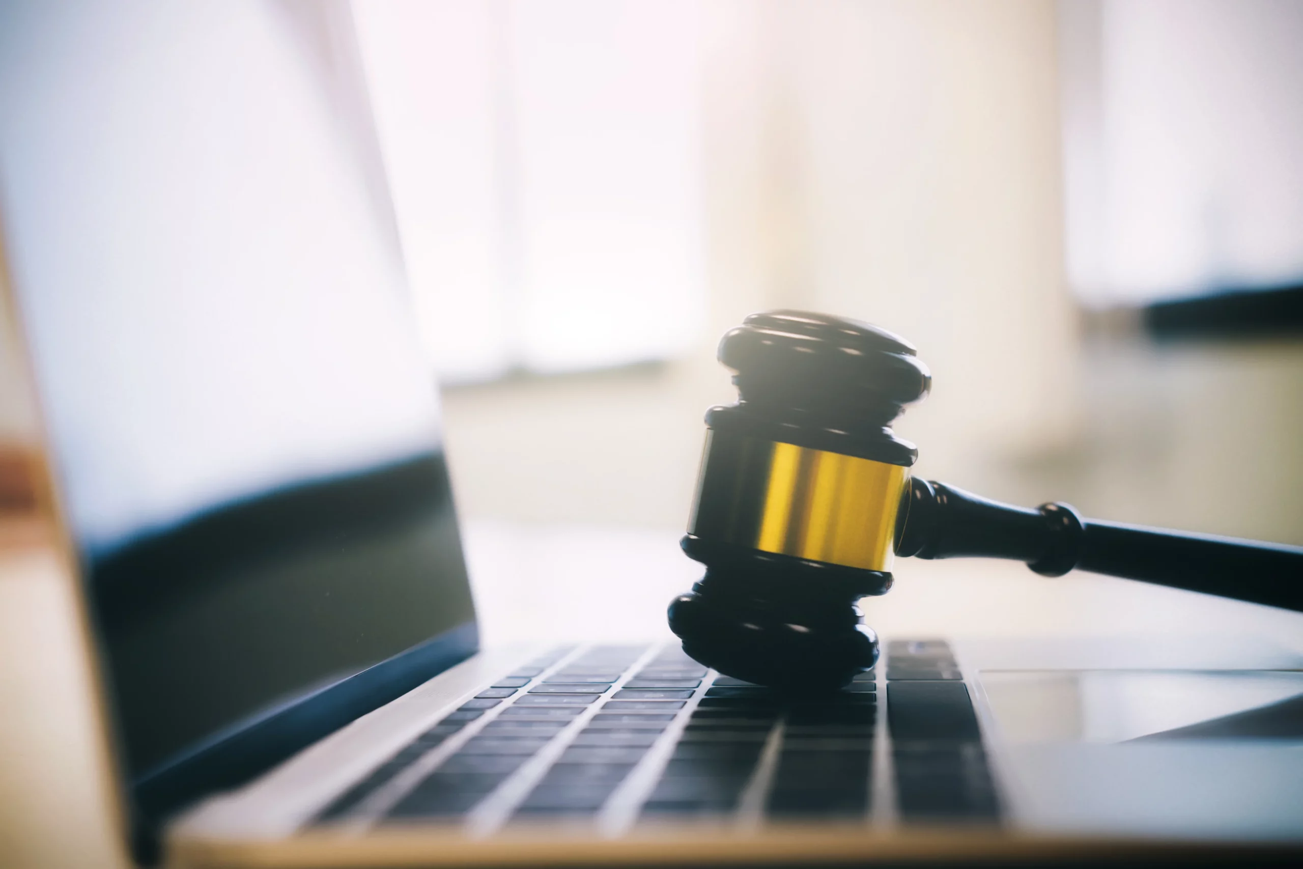 Wooden judge's gavel resting on a laptop keyboard, representing FDCPA violations, debt collection disputes, and class action legal claims in Missouri.